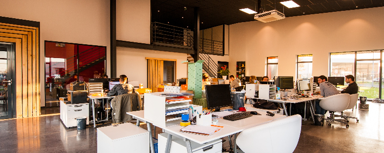 People working at desks in an open office space.